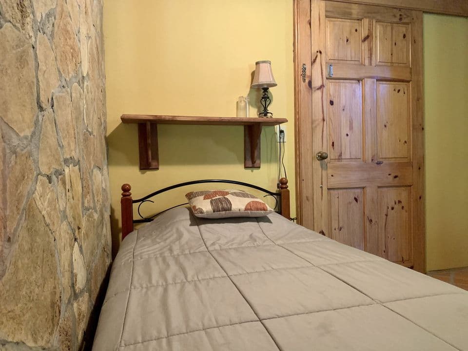 La cama individual junto a la pared de piedra